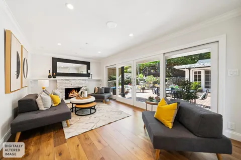 a living room with fireplace furniture and a large window