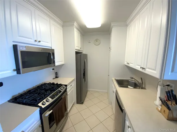 a kitchen with granite countertop a sink stove and refrigerator