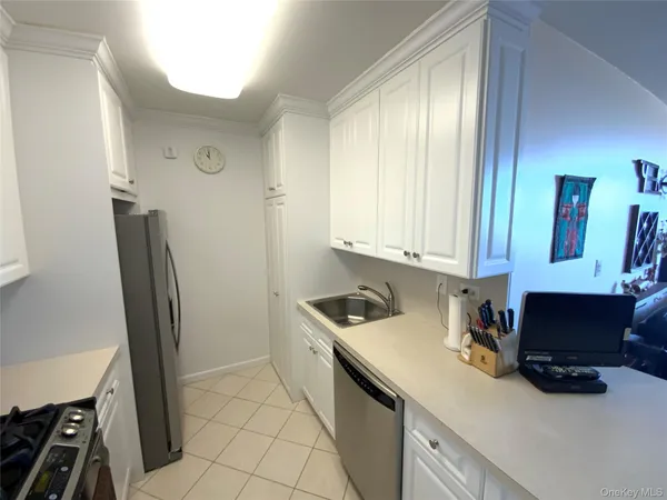 a room with a sink a refrigerator and cabinets