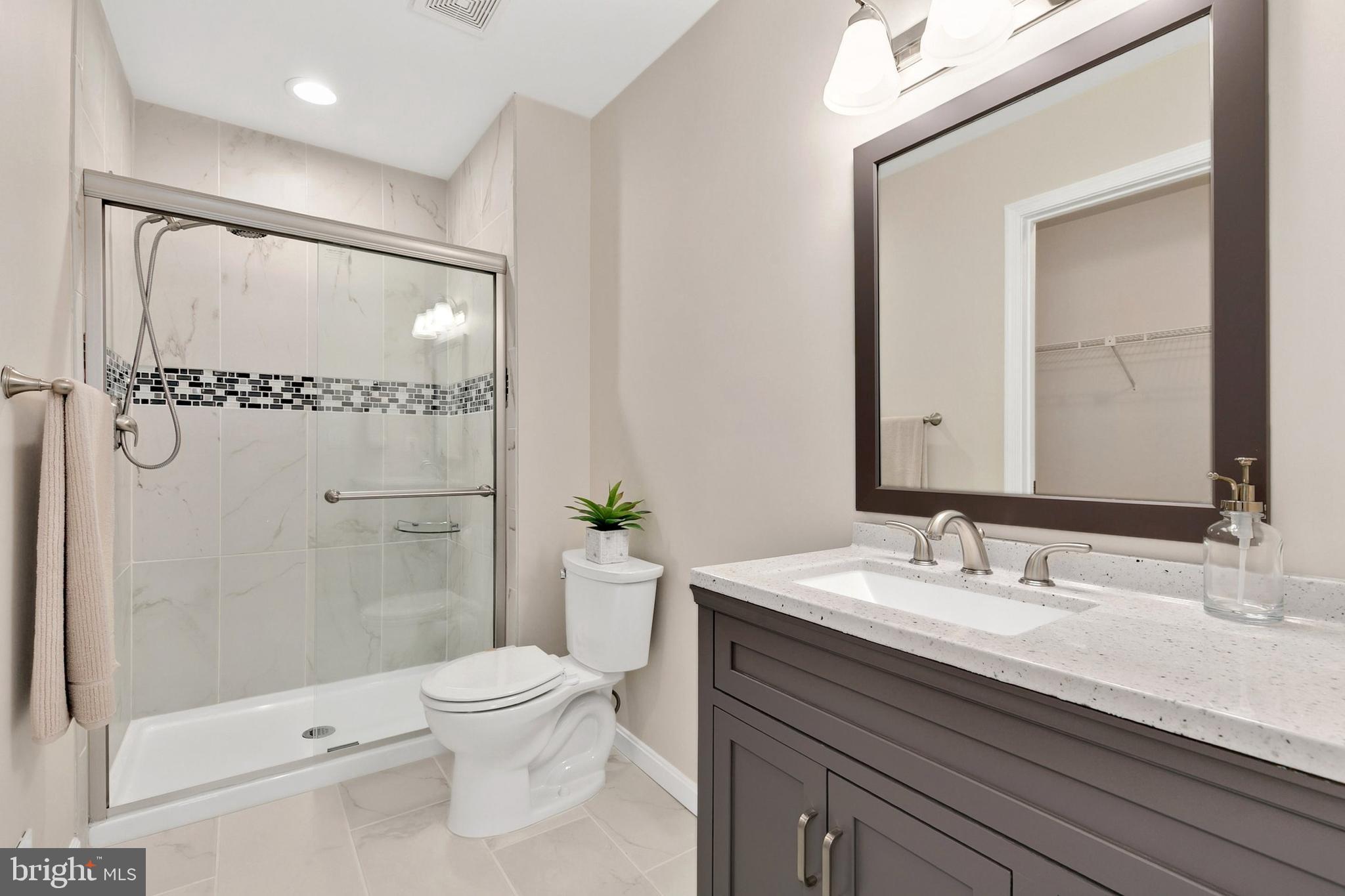 3133 Beaverwood Lane Silver Spring, MD 20906 - Photo 22 of 41 a bathroom with a granite countertop sink a toilet a mirror and shower
