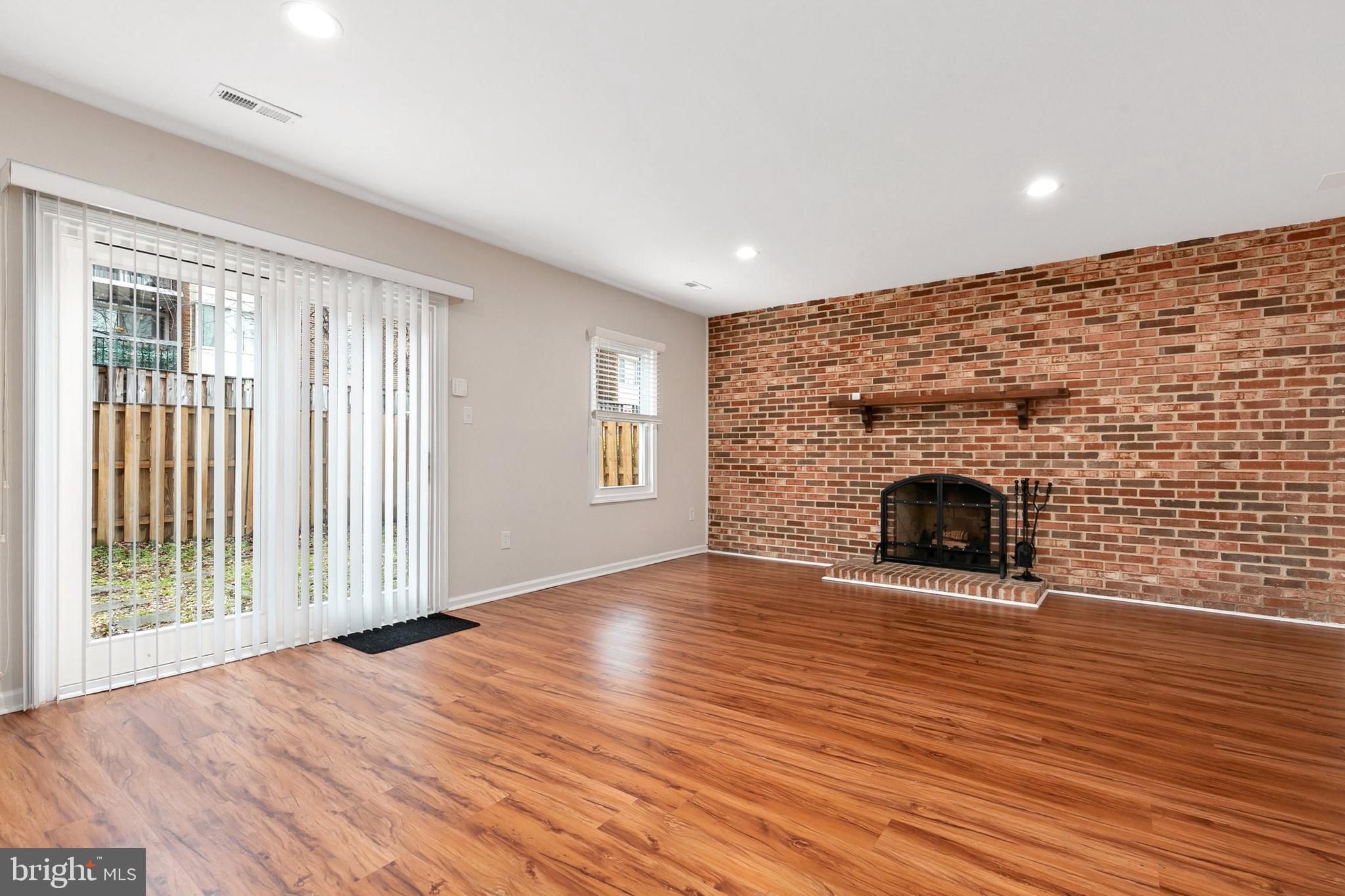 3133 Beaverwood Lane Silver Spring, MD 20906 - Photo 31 of 41 an empty room with wooden floor and fireplace