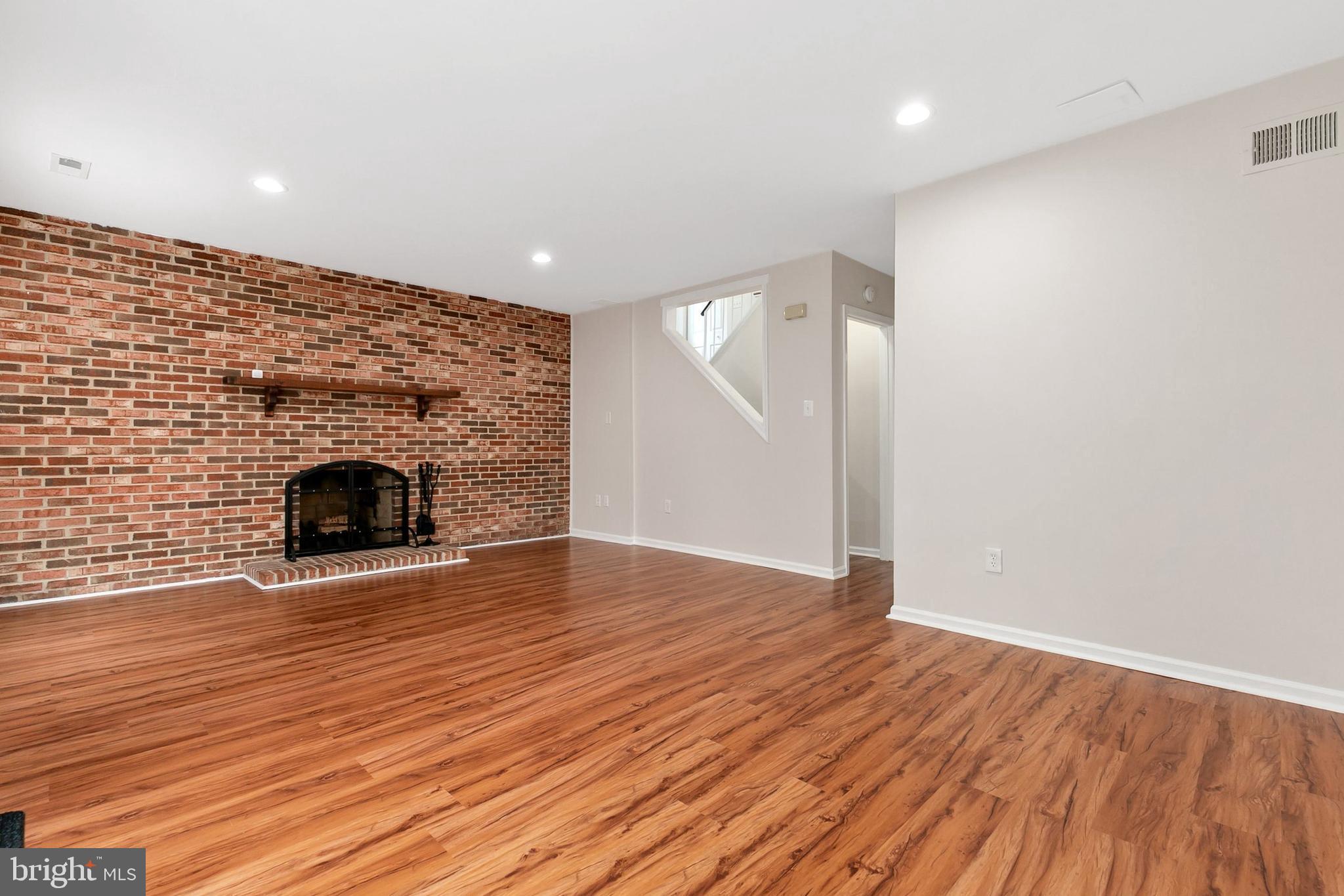 3133 Beaverwood Lane Silver Spring, MD 20906 - Photo 33 of 41 an empty room with wooden floor and fireplace