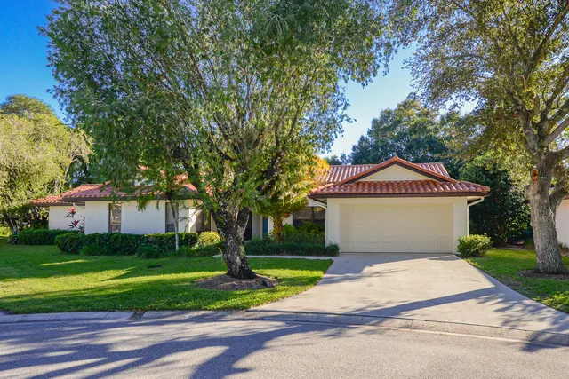 a front view of a house with a yard and trees