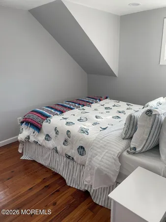 a bedroom with a bed and a wooden floor