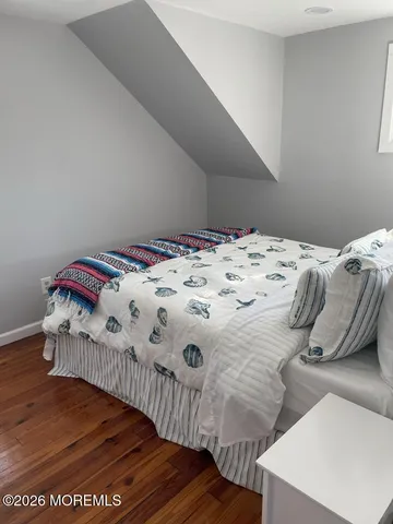 a bedroom with a bed and a wooden floor