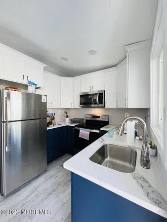 a kitchen with stainless steel appliances granite countertop a refrigerator a sink a stove a microwave and cabinets