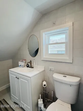 a bathroom with a toilet a sink and mirror