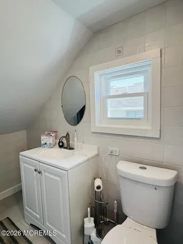 a bathroom with a toilet a sink and mirror