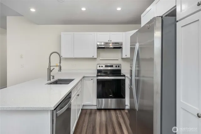 a kitchen with stainless steel appliances a refrigerator sink and stove