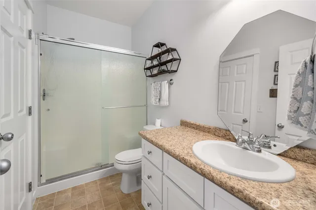 a bathroom with a granite countertop sink toilet and shower