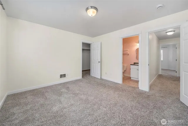 an empty room with closet and bathroom