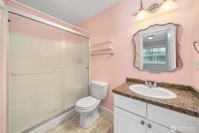a bathroom with a granite countertop sink toilet and shower