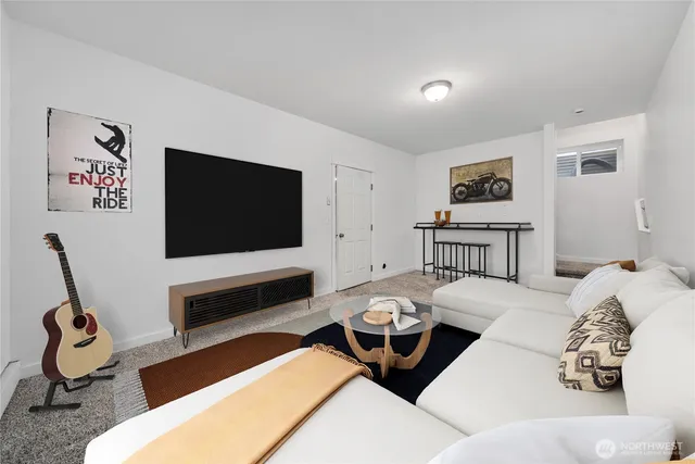 a living room with furniture a flat screen tv and gym equipment