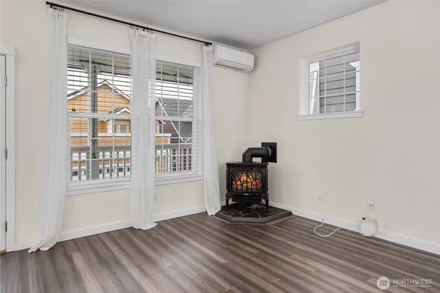 a view of empty room with wooden floor and fireplace