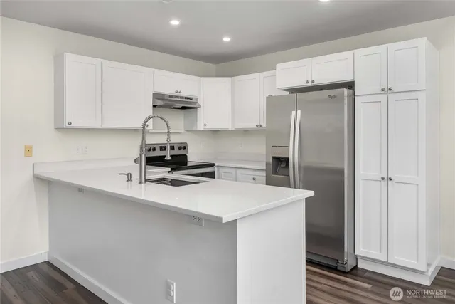 a kitchen with a sink a refrigerator and cabinets