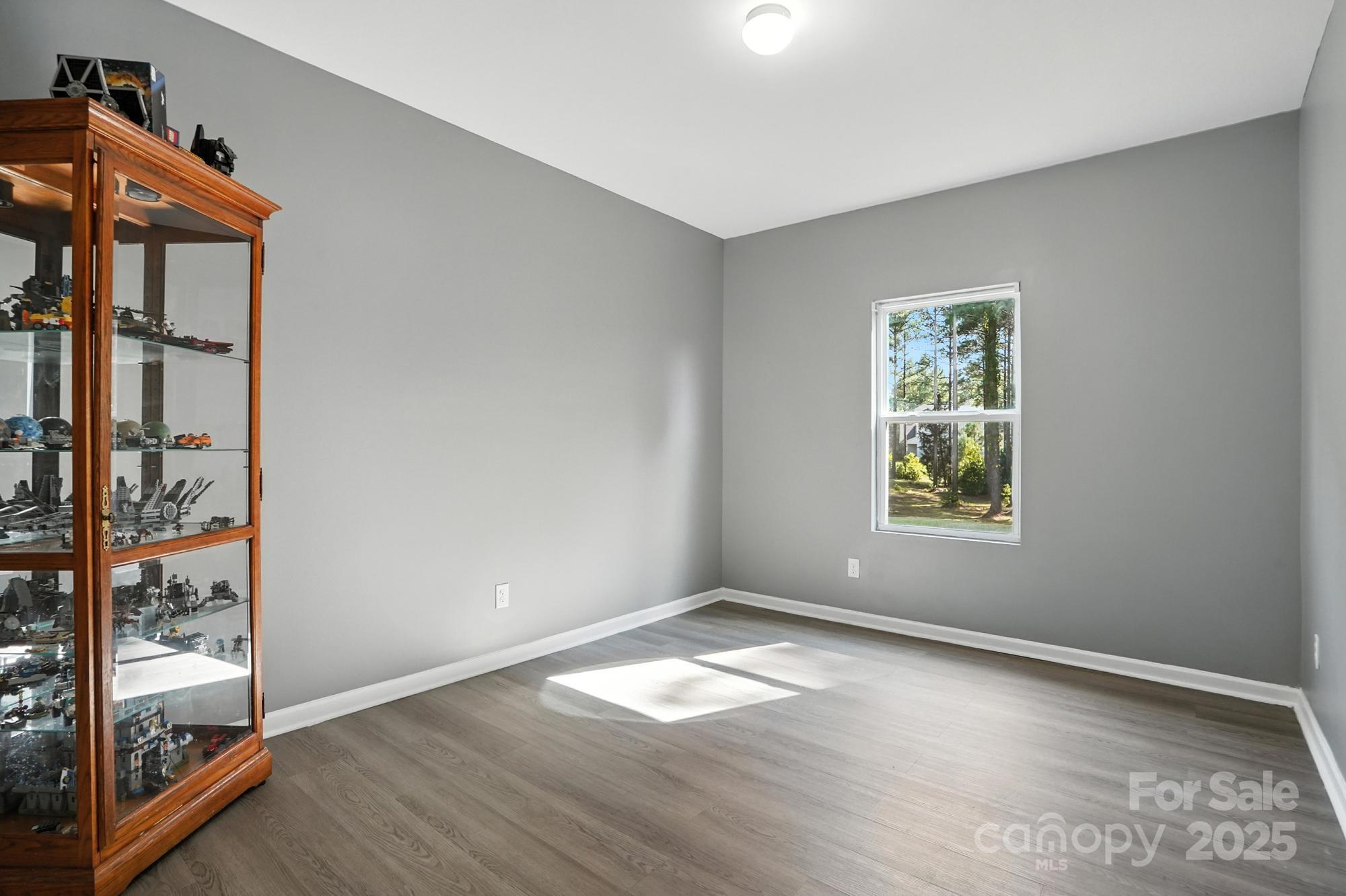 6405 Fawn Crest Drive Waxhaw, NC 28173 - Photo 16 of 38 an empty room with wooden floor and windows