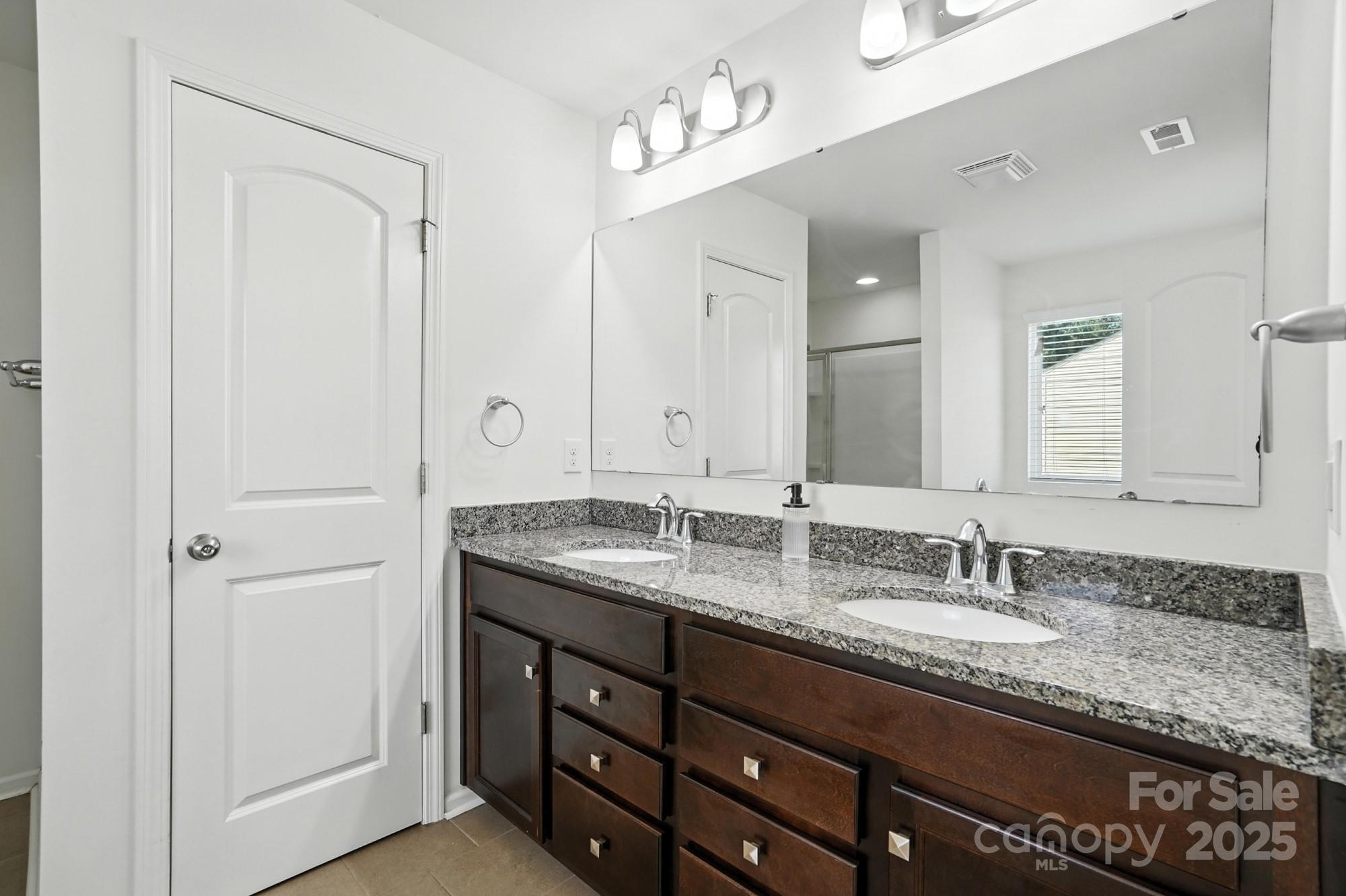 6405 Fawn Crest Drive Waxhaw, NC 28173 - Photo 19 of 38 a bathroom with a granite countertop double vanity sink and a mirror