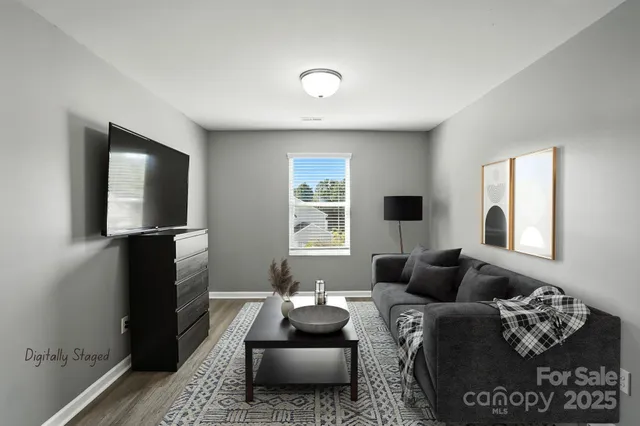 a view of a livingroom with wooden floor and a flat screen tv