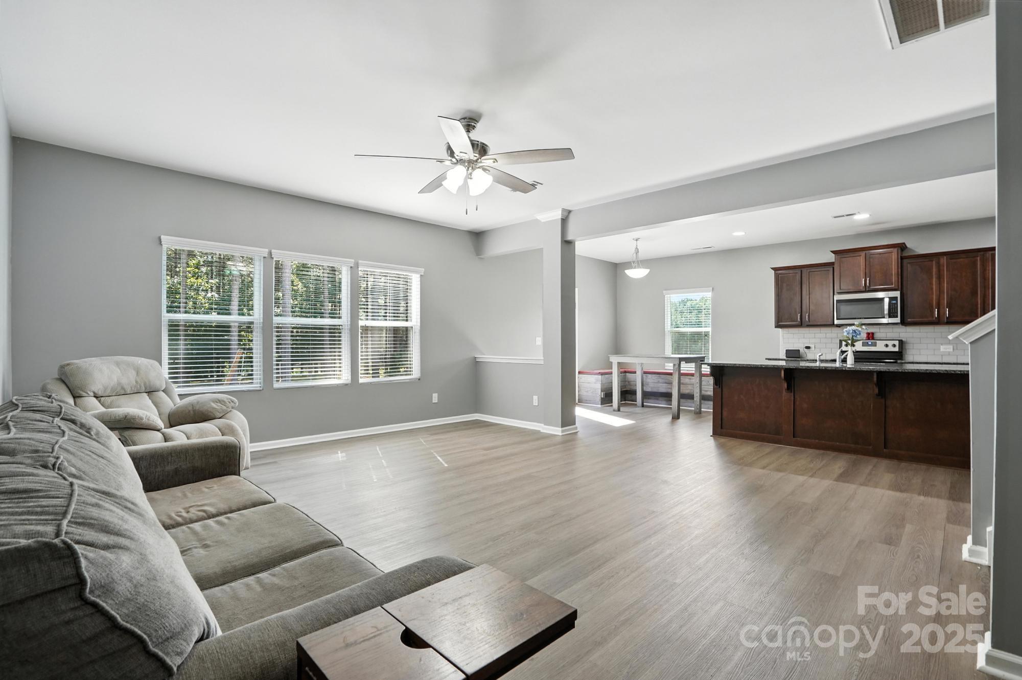 6405 Fawn Crest Drive Waxhaw, NC 28173 - Photo 10 of 38 a living room with couches and kitchen view with wooden floor