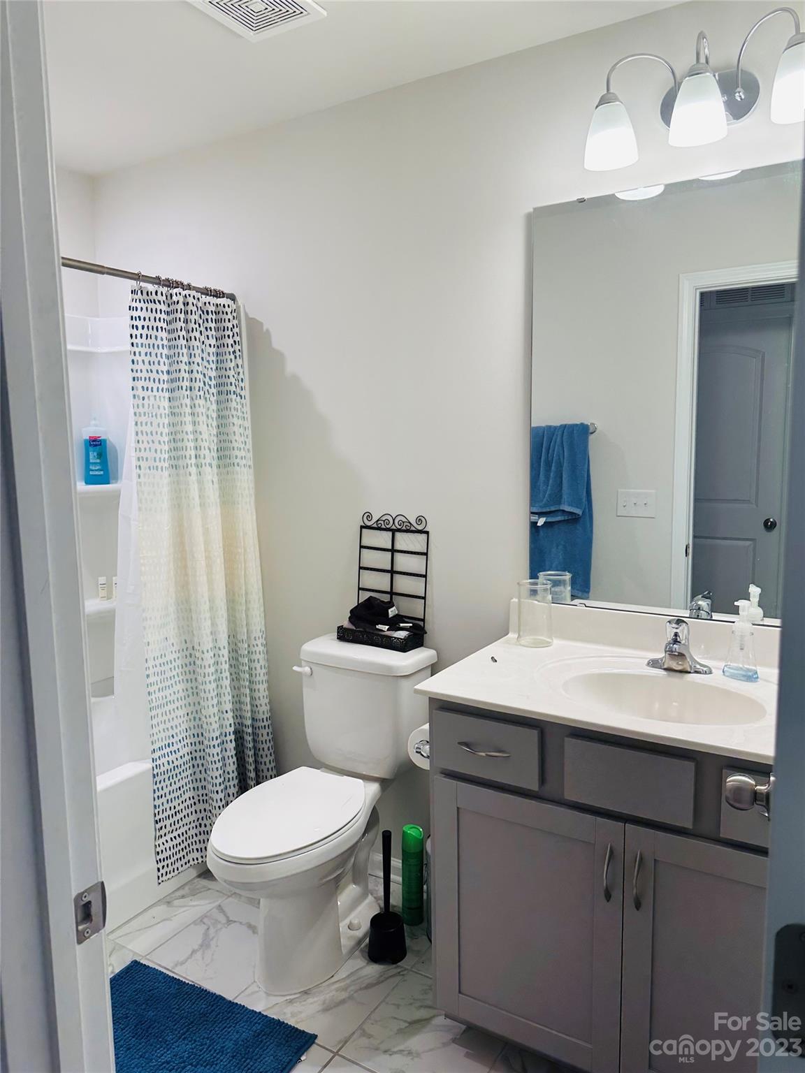 1424 Galloway Road Charlotte, NC 28262 - Photo 12 of 18 a bathroom with a sink a toilet a mirror and shower curtain