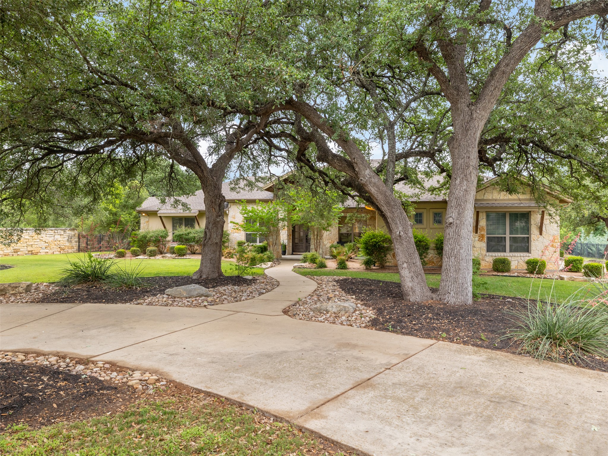 101 Aldea Street Georgetown, TX 78633 - Photo 2 of 40 Mature trees and professionally landscaped garden beds welcome you along the circle drive.