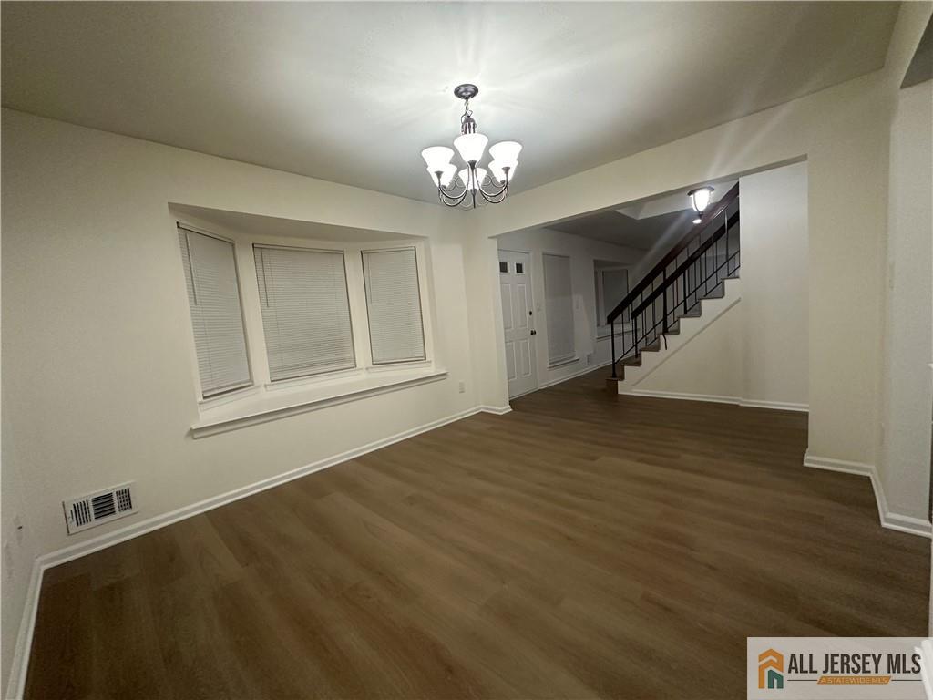 204 Maplecrest Road, Unit 204 Edison, NJ 08820 - Photo 5 of 15 a view of an empty room with chandelier and wooden floor
