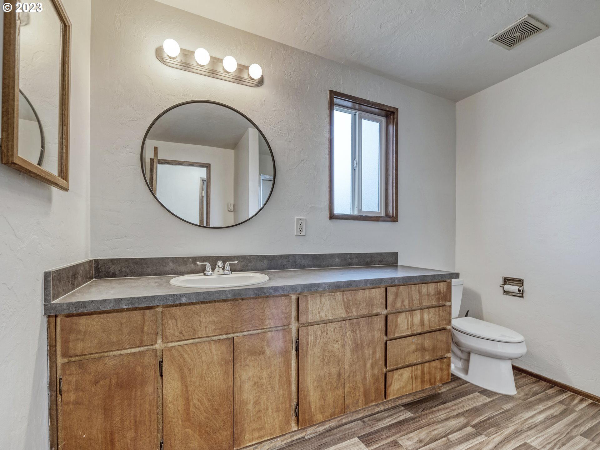 1357 East 43rd Avenue Eugene, OR 97405 - Photo 16 of 28 a bathroom with a toilet a sink and mirror