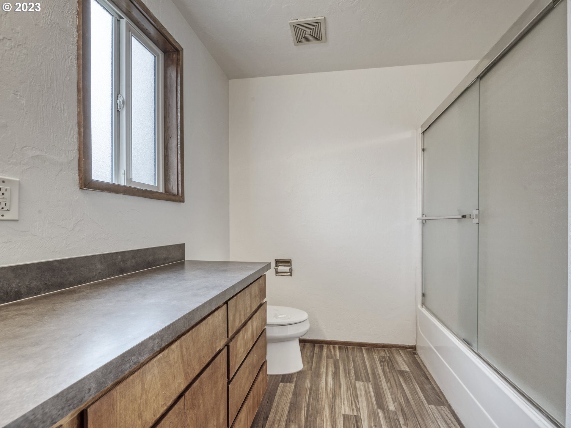 1357 East 43rd Avenue Eugene, OR 97405 - Photo 17 of 28 a bathroom with a sink a toilet and a window