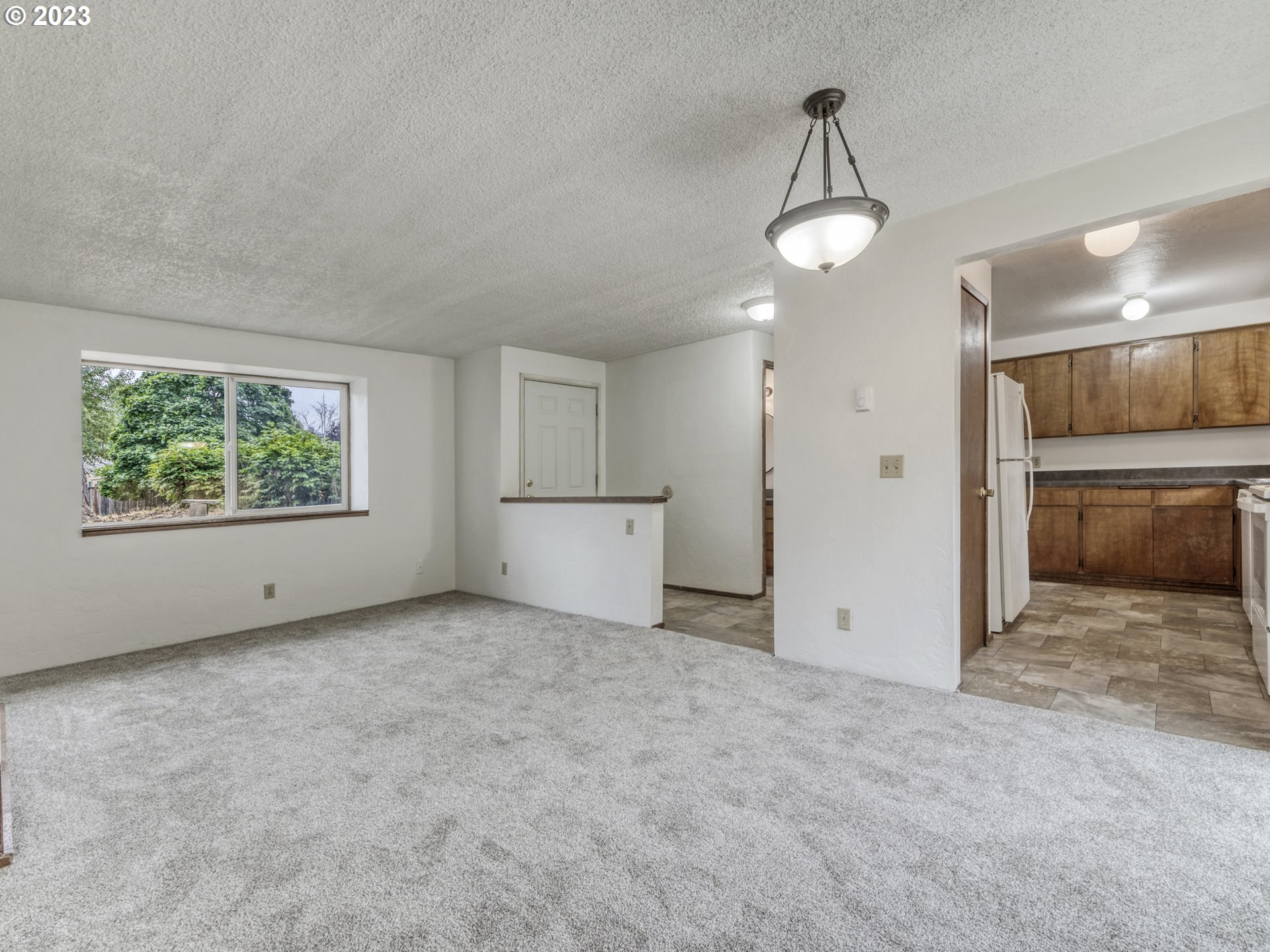 1357 East 43rd Avenue Eugene, OR 97405 - Photo 4 of 28 an empty room with chandelier fan and windows