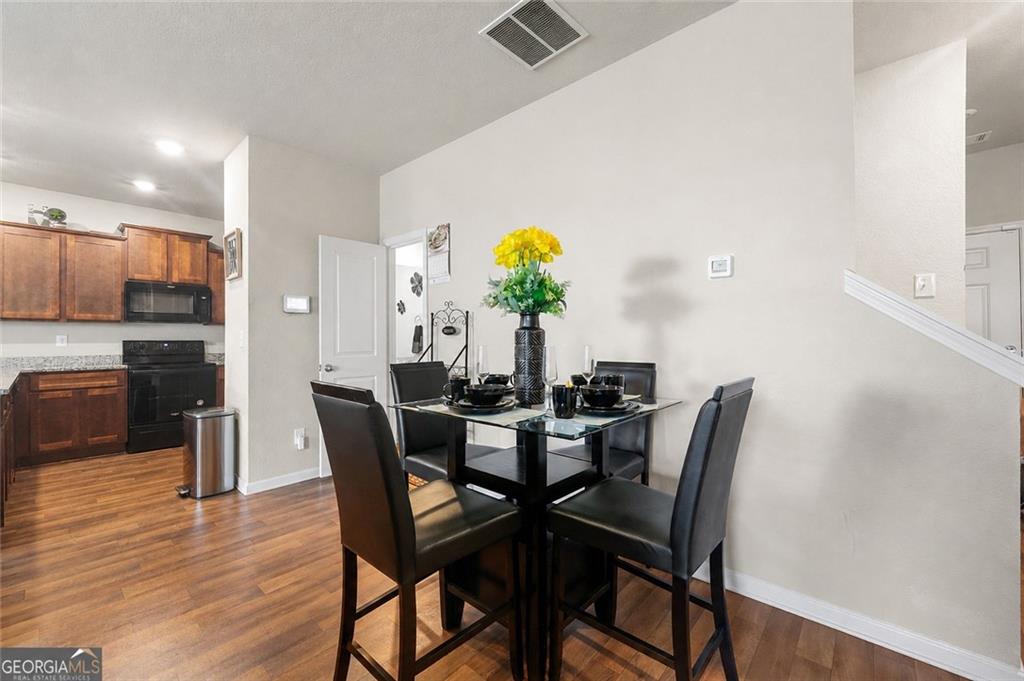 10933 Wheeler Trace Hampton, GA 30228 - Photo 6 of 22 a view of a dining room with furniture and wooden floor