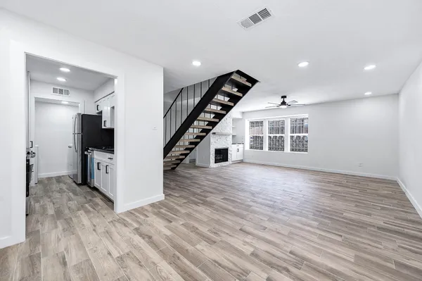 a view of a livingroom with wooden floor and staircase