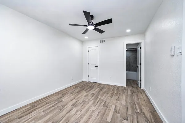 a view of empty room with wooden floor