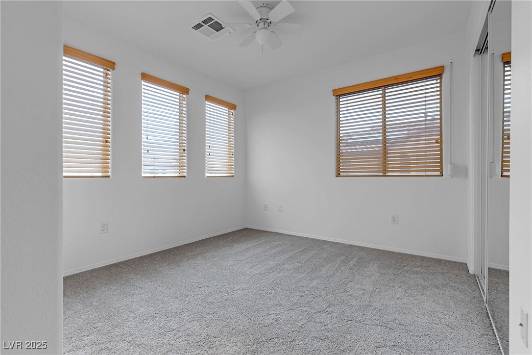 9065 Starling Wing Place Las Vegas, NV 89143 - Photo 15 of 53 Empty room featuring light colored carpet and ceiling fan