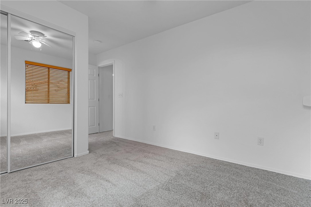 9065 Starling Wing Place Las Vegas, NV 89143 - Photo 23 of 53 Unfurnished bedroom with carpet, a closet, and a ceiling fan