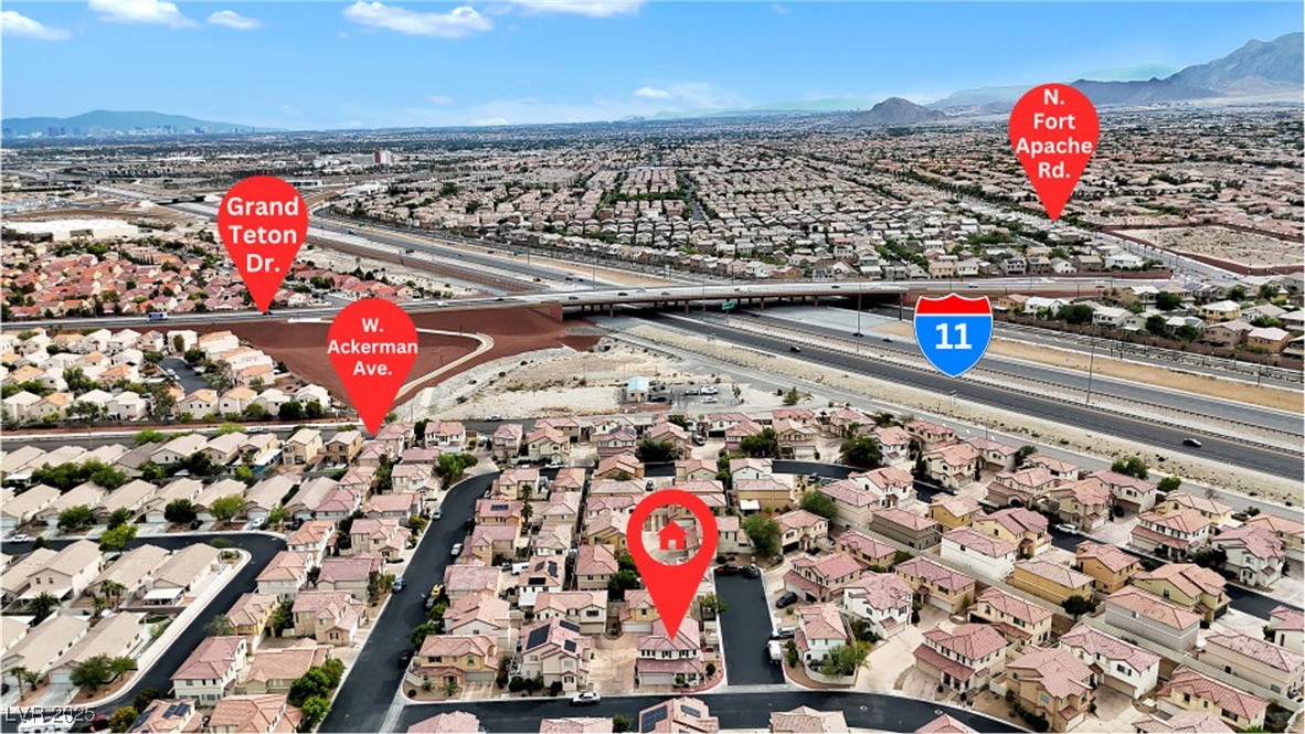 9065 Starling Wing Place Las Vegas, NV 89143 - Photo 41 of 53 Aerial perspective of suburban area with a main thoroughfare and a mountainous background