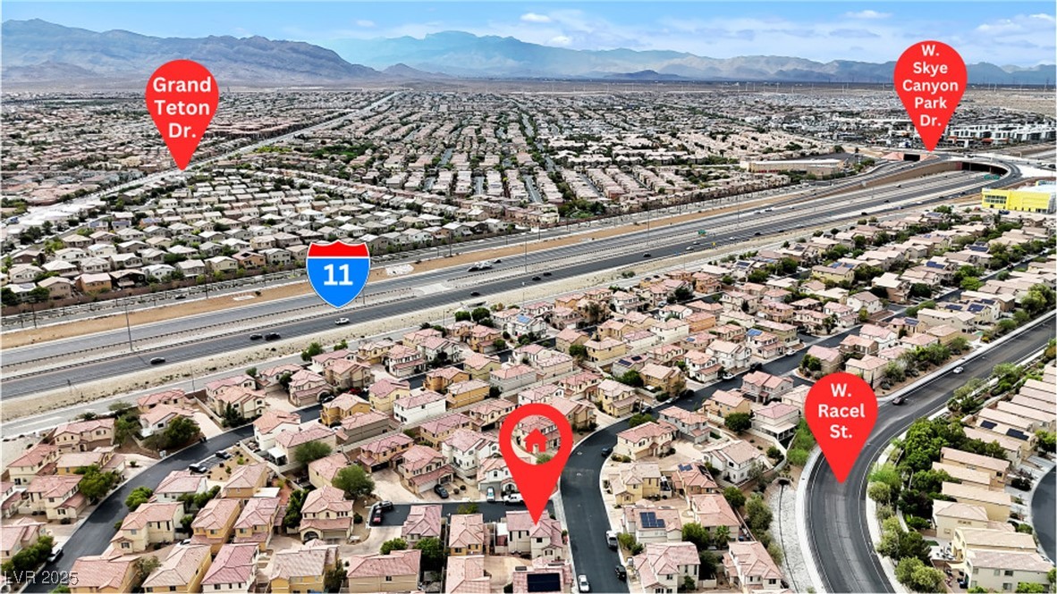 9065 Starling Wing Place Las Vegas, NV 89143 - Photo 45 of 53 Aerial perspective of suburban area with a major roadway and mountains