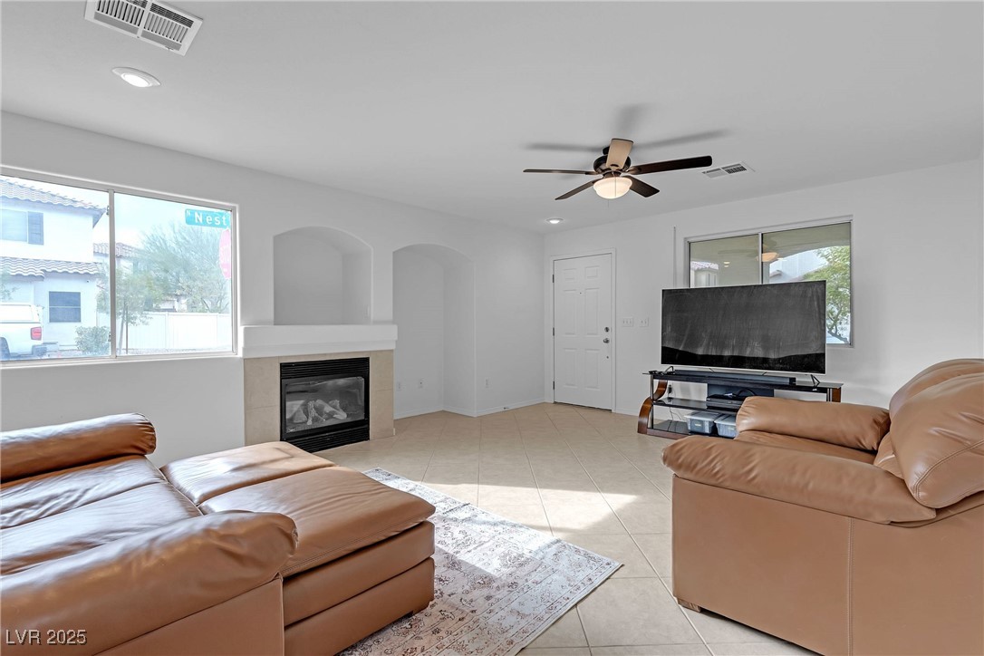 9065 Starling Wing Place Las Vegas, NV 89143 - Photo 6 of 53 Living room featuring a tile fireplace, light tile patterned floors, recessed lighting, and ceiling fan
