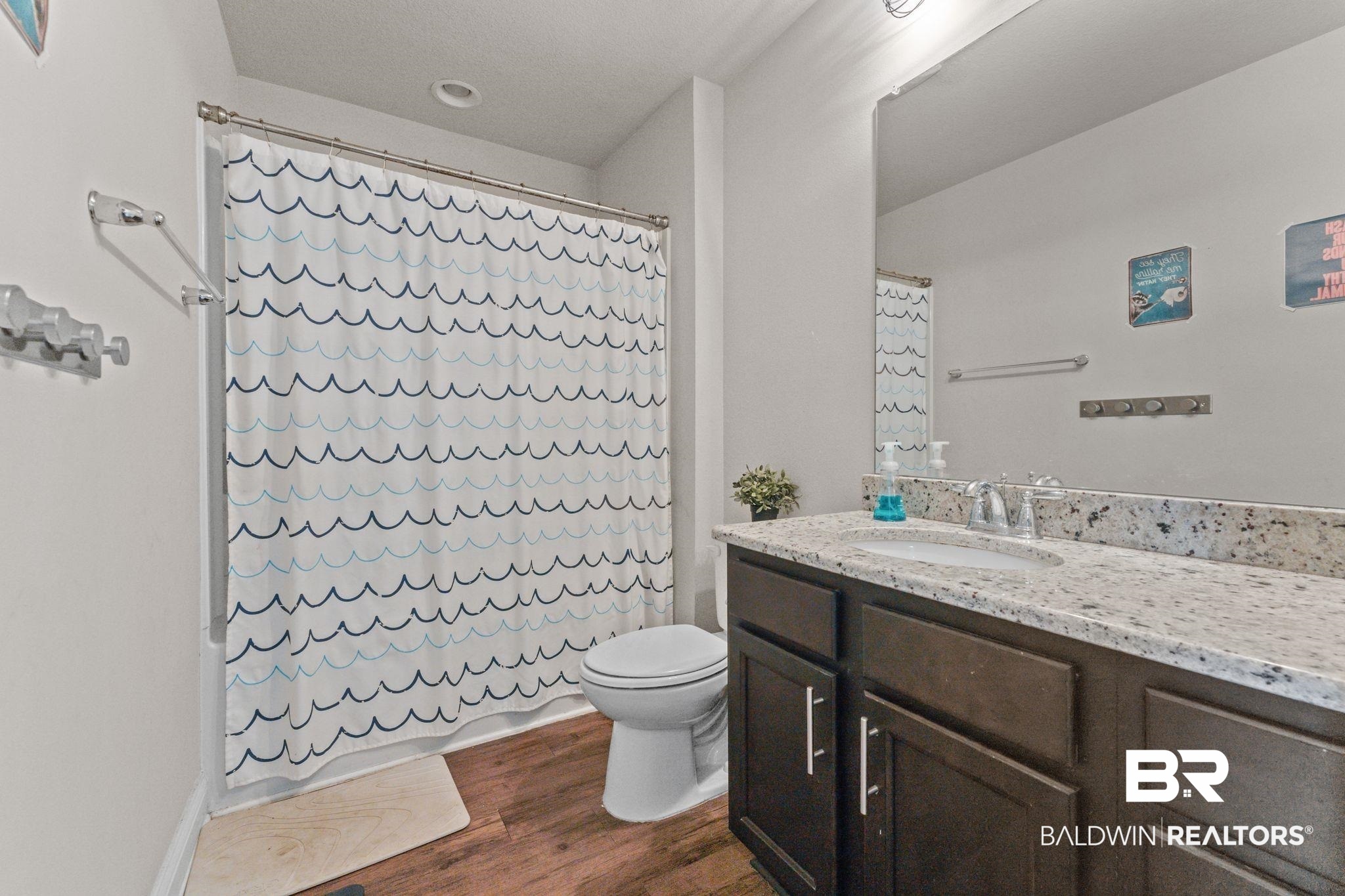 12711 Chickadee Lane Daphne, AL 36527 - Photo 26 of 39 Bathroom with shower / bathtub combination with curtain, vanity, and dark wood finished floors