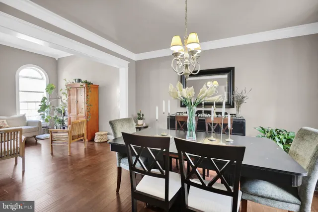 a kitchen with a dining table chairs and view of living room