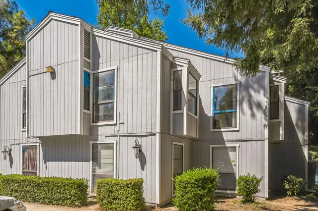 a view of a street with house and a large tree