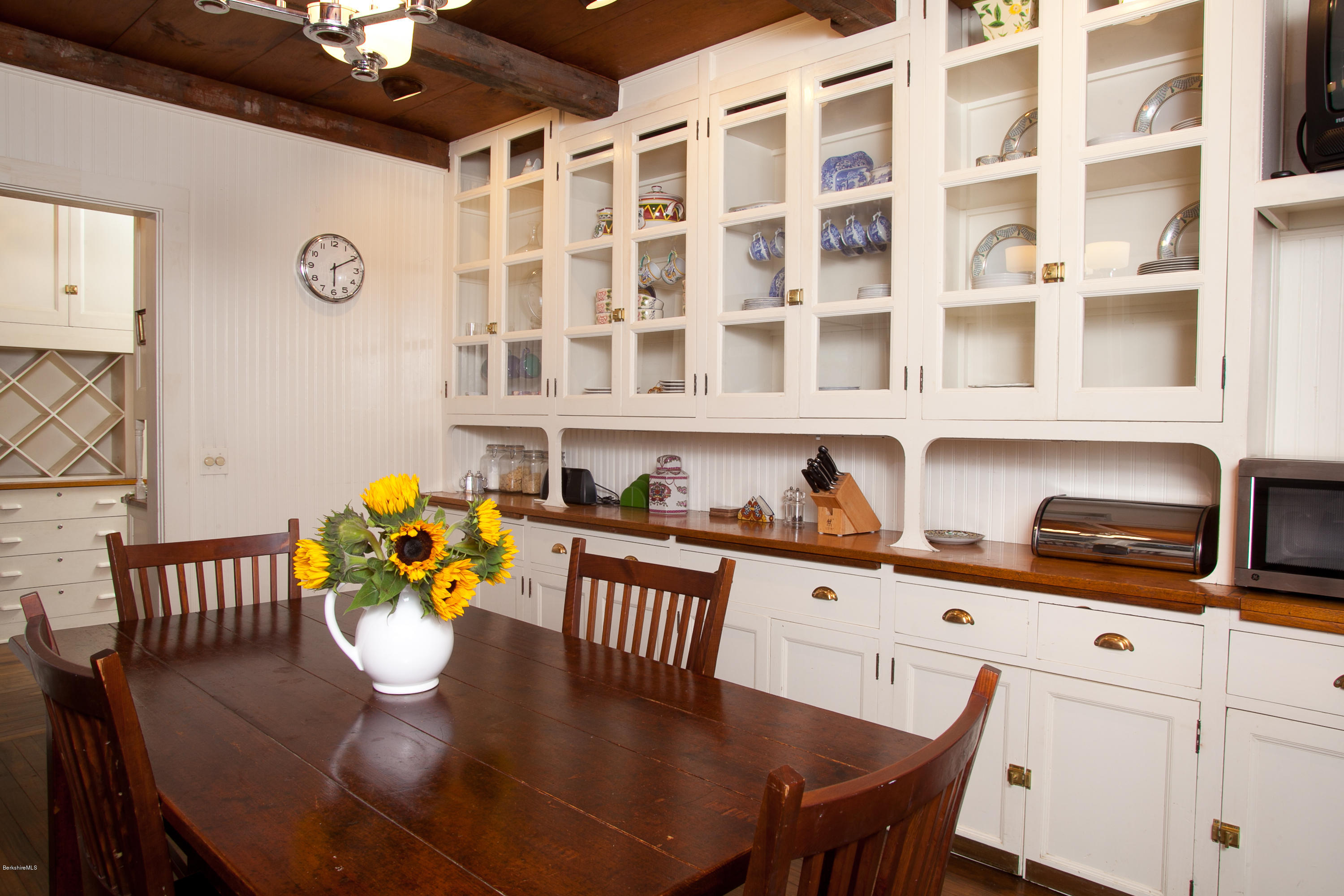 2 Brace Road Tyringham, MA 01264 - Photo 22 of 61 a kitchen with granite countertop a dining table chairs and white cabinets