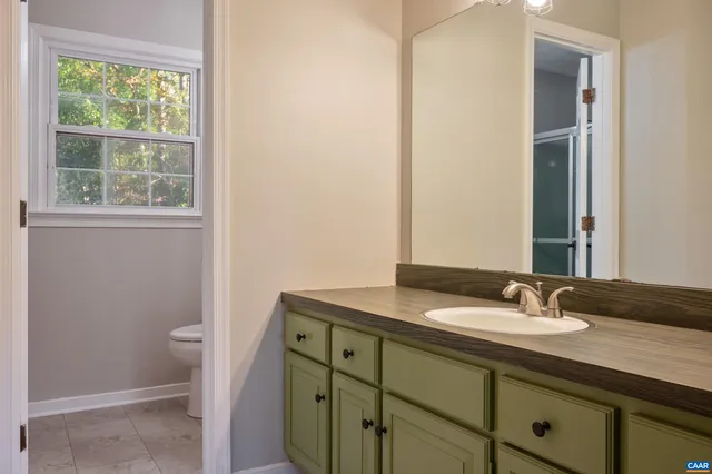 a bathroom with a sink a toilet and a mirror