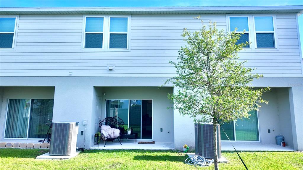 3244 Skyline Loop Kissimmee, FL 34758 - Photo 13 of 13 a view of a house with a yard potted plants and a large tree