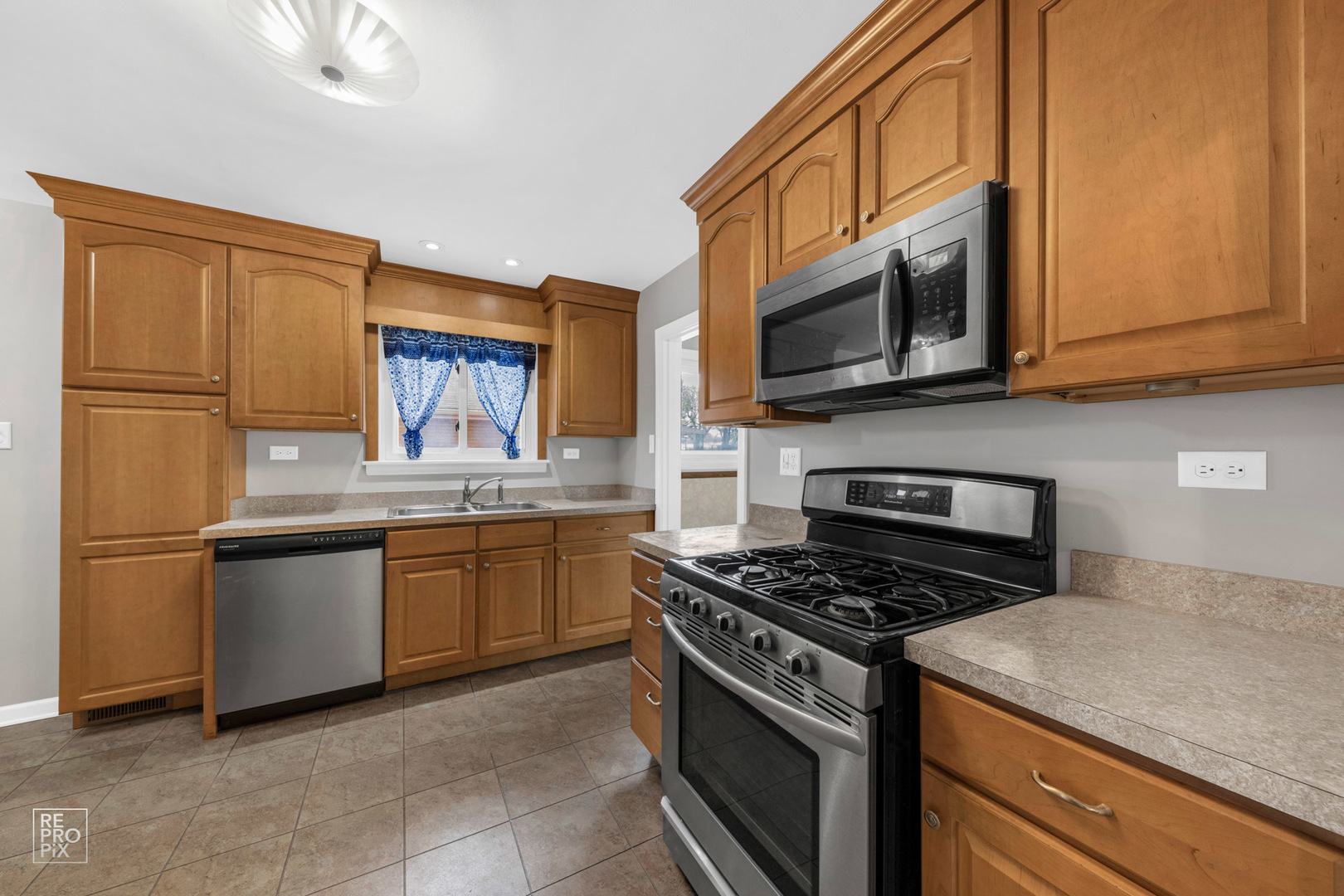 309 North Wolf Road Hillside, IL 60162 - Photo 2 of 10 a kitchen with granite countertop a stove top oven microwave and cabinets
