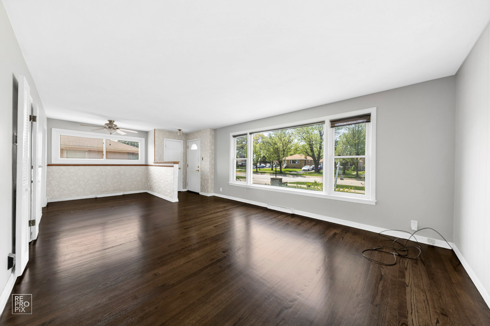 309 North Wolf Road Hillside, IL 60162 - Photo 4 of 10 an empty room with wooden floor and windows