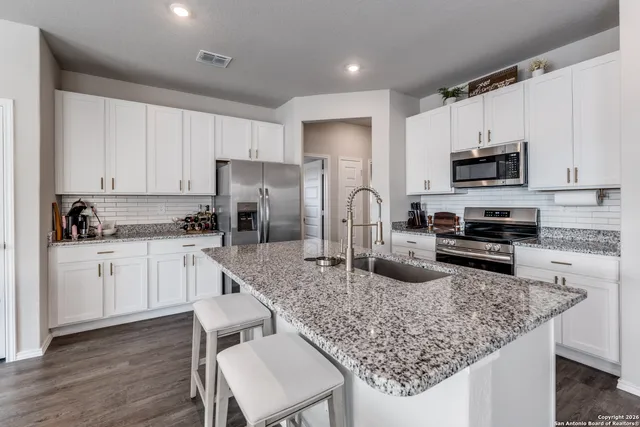 a kitchen with sink stove microwave and refrigerator