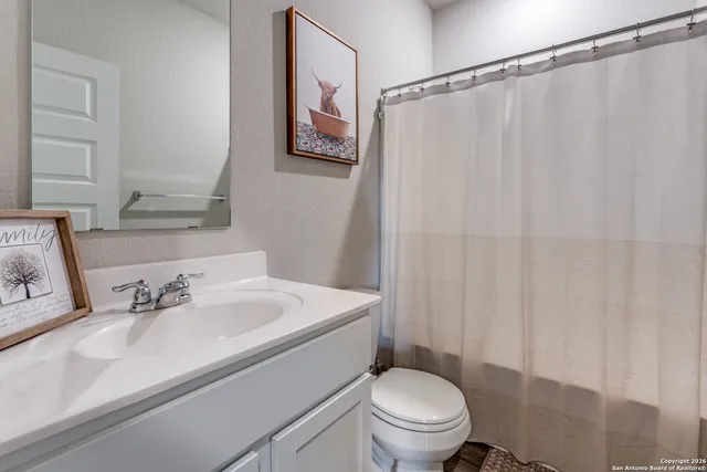 a bathroom with a sink mirror vanity and toilet