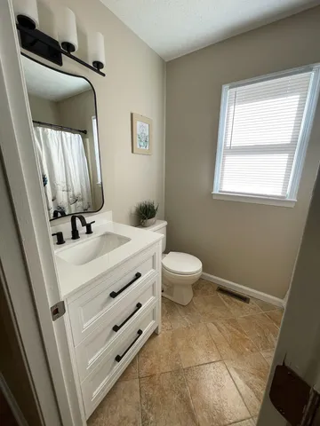 a bathroom with a sink a toilet and mirror