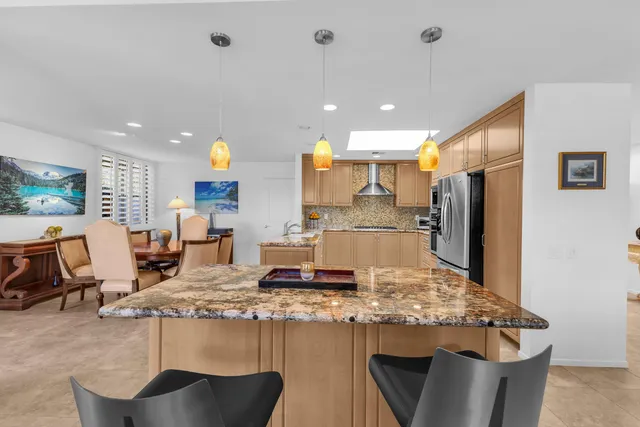 a kitchen with kitchen island granite countertop a stove and a refrigerator