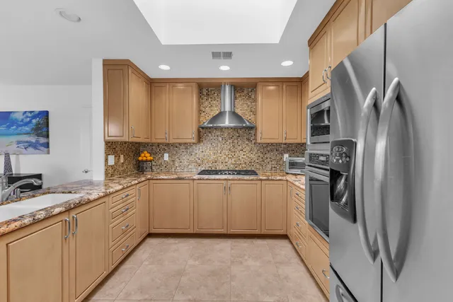 a kitchen with stainless steel appliances granite countertop a refrigerator and a stove